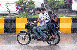 Youngsters ride a bike in rain in Jalandhar on Tuesday