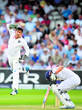 ndias captain Mahendra Singh Dhoni misses a throw as Englands captain Alastair Cook ducks during the second Test at Lords in London. 