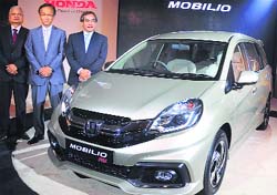 From left: Honda Cars India senior vice-president Raman Sharma, CEO Hironiri Kanayama and Honda Motor Companys managing officer Yoshiyuki Matsumoto pose with MPV Mobilio at its launch in New Delhi on Wednesday. Tribune photo: Mukesh Aggarwal