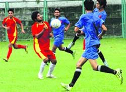 Players try to take control of the ball in a match in the Nemidas District Football League at Pavilion Ground in Dehradun on Wednesday. A Tribune photograph
