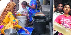 A woman makes the most of an illegal water supply connection (and right) local residents show the contaminated drinking water in Jalandhar