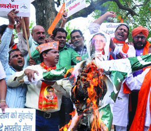 Shiv Sena activists shout slogans against Pakistan and burn an effigy of Pakistan Prime Minister Nawaz Sharif during a protest against the killing of an Indian soldier in Akhnoor district, Jammu and Kashmir, in New Delhi on Thursday.