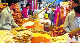 A shopkeeper sells snacks on a road ahead of Eid in Srinagar on Thursday.