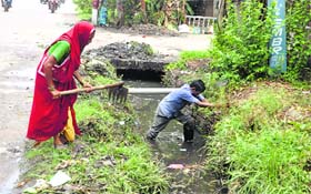 Employees of the Municipal Corporation clear a choked drain in Jammu.
