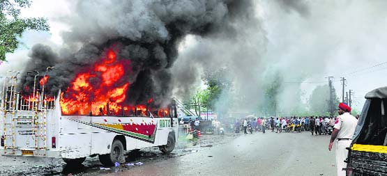A private bus set on fire by a mob after the death of an auto-rickshaw driver in an accident in Pathankot on Thursday. Tribune Photo: Malkiat Singh
