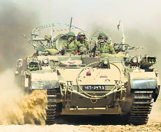 An Israeli army armoured vehicle moves along the border 