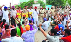ETT teachers hold a protest; and (below) a policeman stands guard near a barricade at Phase VIII in Mohali on Friday. Tribune photos: Vicky Gharu 