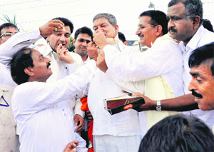 Chief Minister Harish Rawat and Congress supporters celebrate the partys victory in the Assembly byelections at Congress Bhavan in Dehradun on Friday