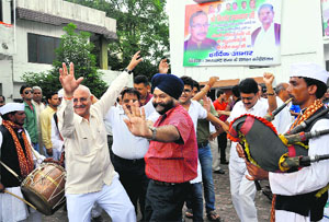 Congress workers celebrate in Dehradun on Friday
