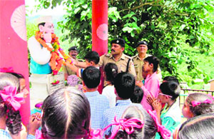 Schoolchildren and police jawans offer floral tributes on a statue of Sridev Suman on his 70th death anniversary at his native Jual Village in Chamba on Friday