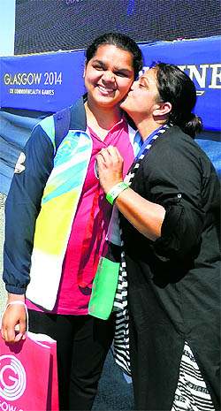 Malaikas mother tries to plant a kiss on the cheek of her daughter after she shot a silver in the Commonwealth Games. 