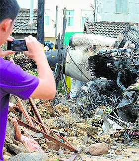 A man takes pictures at the wreckage of TransAsia Airways that crashed in Magong in the Penghu islands, on Friday.