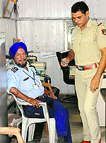 A police official questions Harjinder Singh after his gun went off accidentally while he was loading it in the parking lot of the Bank Square, Sector 17, Chandigarh, on Saturday. 
