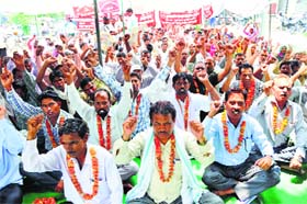 Government employees under the banner of the Sarv Karamchari Sangh during the fast in front of the Mini-Secretariat in Karnal on Saturday