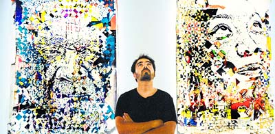 Portuguese street artist Vhils poses in front of one of his works during the exhibition “Dissection” at the Museum of Electricity in Lisbon.