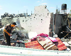 A Palestinian man inspects the rubble of a house east of Khan Yunis in the southern Gaza Strip on Saturday.