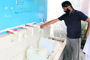 A man takes water from a Reverse Osmosis (RO) plant installed in Bathinda.