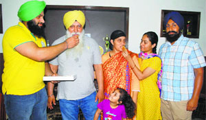 Family members of Navjeet Kaur Dhillon celebrate her bronze medal win in discus throw at the World Junior Athletics Championship in USA, at their home in Amritsar on Sunday. 