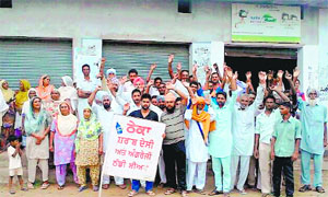 Residents protest in front of the liquor vend that they force-locked at Raoke Kalan village in Moga district on Sunday.