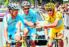 Vincenzo Nibali (right), who began the day with a near eight-minute lead, celebrates with a glass of champagne with Astana teammates during the last stage on Sunday.