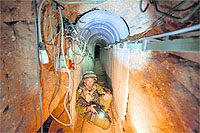 An Israeli army officer in a Palestinian tunnel that runs from the Gaza Strip into Israel. Israel says its current military campaign is aimed at destroying the tunnels.