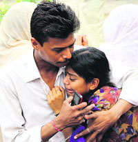 A neighbour consoles the daughter of the deceased in Bathinda on Monday