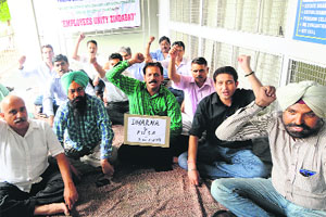 Members of the Panjab University Staff (Non-Teaching) Association shout slogans on the campus in Chandigarh on Monday.