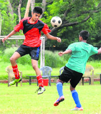 Players vie for the ball during a football match between Saupins School and Chitkara International School at Sector 26, Chandigarh, on Monday.