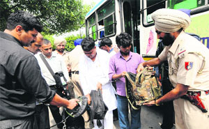 Police personnel frisk luggage of passengers during a special checking drive at the ISBT, Sector 17, Chandigarh, on Monday.