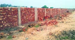 Fourteen months after the construction for the NID started, all there stands is a boundary wall. Tribune photo