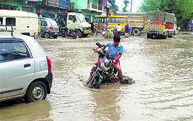 A motorcycle rider on a water-logged Kullu-Manali national highway near Ner Chowk in Mandi on Monday.