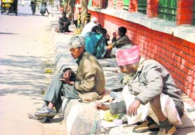 Beggars sit on a roadside in Ludhiana