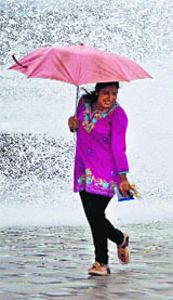 A woman enjoys a high tide in Mumbai on Monday
