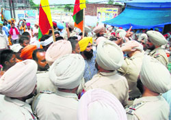 Policemen stop protesters from moving towards the disputed site of the Ram Tirath Temple near Amritsar on Monday.