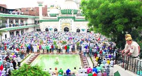 Cops stand guard as devotees offer prayers at the historical Mosque Kharudin on Eid ul-Fitr in Amritsar on Tuesday.