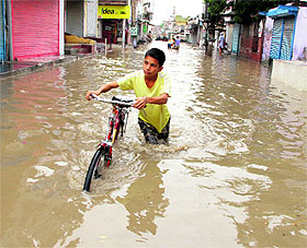A child wades through a waterlogged street in Parasram Nagar