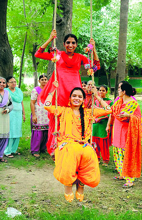 Girls enjoy themselves on a swing during the Teej celebrations in Bathinda on Tuesday.