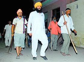 Armed with sticks, residents hold thikri pehra to prevent any strike by the kala kaccha gang at Nagla village near Zirakpur on Tuesday night.