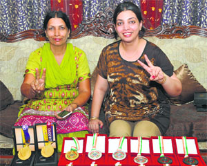 Harpreet Singhs mother Amarjeet Kaur (left) and sister Jasmeet Kaur with the shooters medals at their home in Karnal on Tuesday.