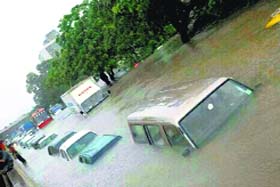 Vehicles stuck on a flooded road during heavy rains in Valsad district on Tuesday