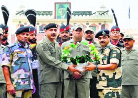 Sharing happiness: BSF Deputy Inspector General MF Farooqui (second from left) gives a gift to Pakistani Ranger Wing Commander Asher Khan on Eid at the Attari-Wagah Joint Check post near Amritsar on Tuesday