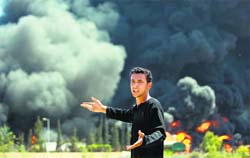 A Palestinian man reacts as flames engulf the fuel tanks of the only power plant supplying electricity to the Gaza Strip after it was hit by overnight Israeli shelling, on Tuesday. AFP