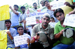 Civil Services aspirants polishing shoes near Palika Bazar during the protest against Civil Services Aptitude Test (CSAT) conducted by the Union Public Service Commission (UPSC) in New Delhi on Wednesday.