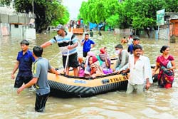 Fire and Emergency Services personnel tow a boat with patients trying to reach the Civil Hospital in Ahmedabad on Wednesday. AFP