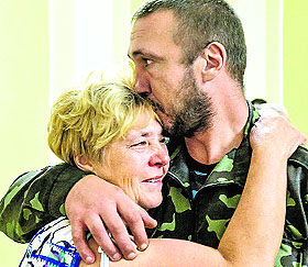 A Ukrainian serviceman, who was captured and jailed by pro-Russian militants in Gorlivka, eastern Ukrainian Donetsk region, reunites with a relative in the office of the Ukrainian President in Kiev.