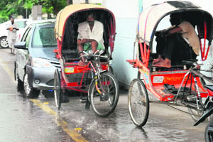 Rickshaw pullers take shelter from rain in Bathinda on Thursday.
