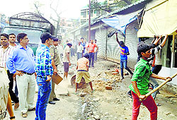 Members of the demolition team remove encroachments near the Civil Hospital in Kangra on Thursday