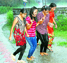 Girls enjoy the rain in Dharamsala on Thursday