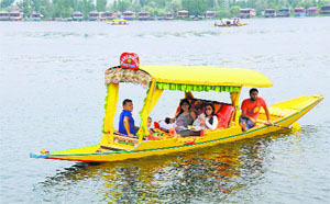Tourists enjoy a ride on a shikara on the Dal Lake in Srinagar.