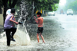 Children play with rainwater in Ludhiana